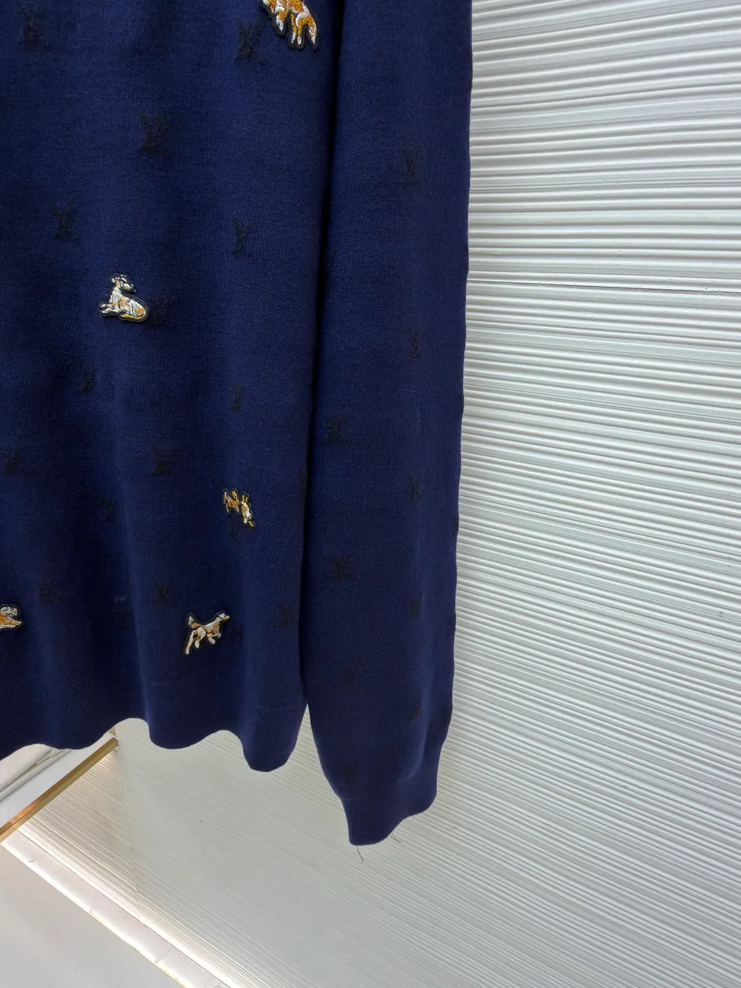 LOUIS VUITTON animal embroidered wool crew neck sweater ●Original version: purchased and developed by 18025 ●Item number: 1682089-B05 ●Fabric: wool blended fabric ●Technology: knitted embroidery production ●Color: navy blue ●Version: fitted version ●Weight: about 590 grams ●Size: XS-S-M-L ●Description: This Louis Vuitton navy blue sweater is made of ultra-fine merino wool blended yarn and is knitted by worsted knitting technology. It uses 16-needle high-density plain knitting technology to give the fabric a silky delicate touch and matte texture. The base of the body is also woven with a mini Monogram pattern using a same-color dark jacquard technology. The pattern is low-key and naturally blends with the wool texture. The decorative details embellished on the body are made of hand-made beading and metal veneer inlays. The veneer is aged by electroplating and enamel color-filled. Every decoration is hand-positioned and sewn by craftsmen to ensure firmness and a beautiful arrangement. The round neckline adopts double-needle overlock knitting technology, which is not easy to deform and fits the neck. The side seams and hem of the body use seamless splicing technology to reduce friction when wearing. The overall stitching is even and fine, fully demonstrating the brand's exquisite craftsmanship and detail control in the field of knitted garments. The overall wiring is straight and delicate, the fabric is comfortable and soft, and the color is consistent without color difference. It can be matched with the same style to create a fashionable look and control various occasions. Customized accessories, complete with three standards, same style for men and women!